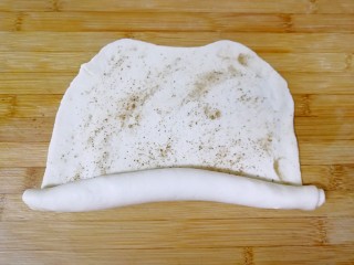 烧饼夹烤肉,将面皮从一头向另一头卷起来。