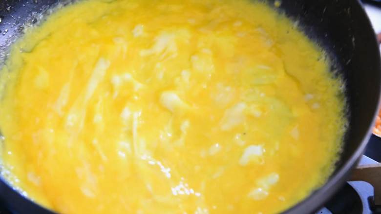简易蛋包饭—黄金满兜的好运蛋包饭，你必须了解一下,蛋液倒入锅中，中小火慢煎铺平至边缘有点微微翘起。