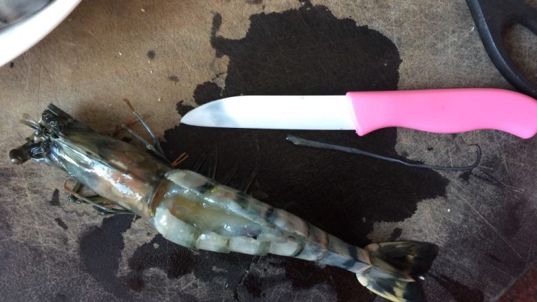 油焖大虾,在虾的头部开个小洞，去除沙包，用小刀开背，去除虾肠