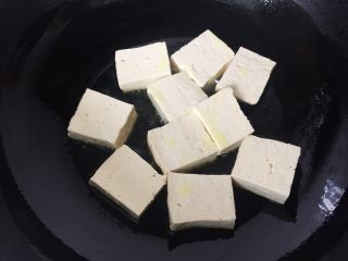 家常老豆腐火腿煲,油锅烧热，豆腐分批下锅，煎至二面金黄