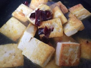 家常老豆腐火腿煲,放上适量火腿片，放盐，大火煮开，小火慢炖，让鲜味慢慢渗入豆腐中