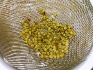 绿豆莲子薏仁甜汤,用筛网滤去浮在表面的绿豆皮