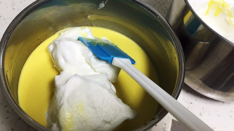 香葱肉松蛋糕卷,取三分之一的蛋白霜进蛋黄糊中。