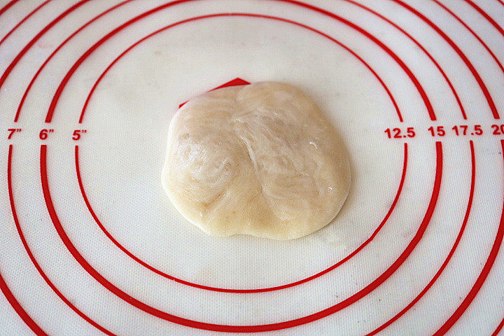 芝麻椒盐牛舌饼,用擀面杖擀成边薄中心厚的圆片。