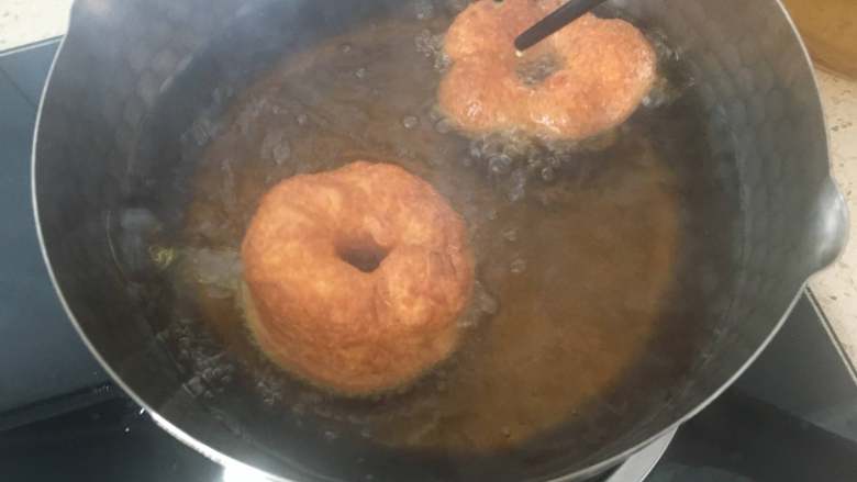 美味油炸版甜甜圈,把发酵好的甜甜圈取出，放入油锅内中小火，炸至两面金黄色即可