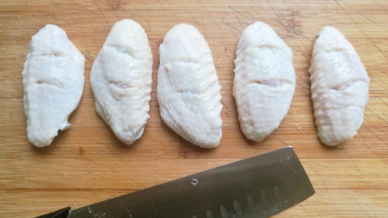 薯片鸡翅,捞出后，用刀在鸡翅的两面划上两刀，这样腌制的时候更容易入味。
