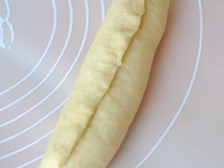 桂花南瓜面包,由馅的一端卷起，最后将收口捏紧。