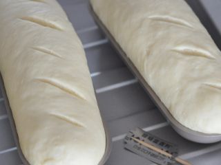 桂花南瓜面包,用刀片在面包表面斜着割口。