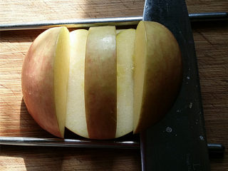 天鹅戏水,如图将刀贴着筷子，横切至竖切面交汇处，这样就切下左、右两小块苹果，剩下的部分：则是用来做天鹅身体的