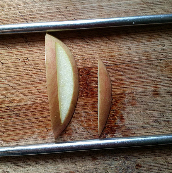 天鹅戏水,取其中小块苹果放到2根筷子中间，按图3~图4的方法，切出三片来