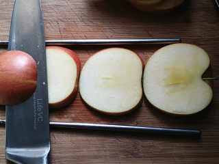 天鹅戏水,将另一半苹果，切面朝下放至2根筷子中间，贴着筷子将苹果横切成4片