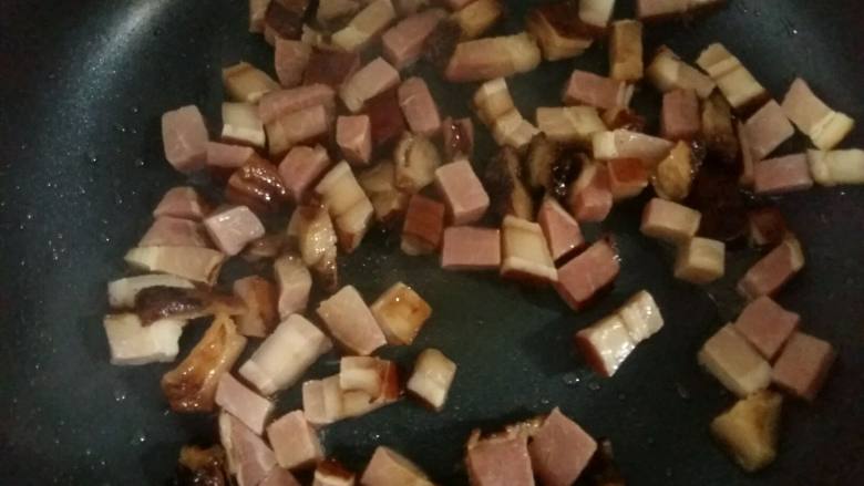 腊肉土豆焖饭,倒入腊肉小火翻炒2分钟，炒出腊肉的香味和油脂。