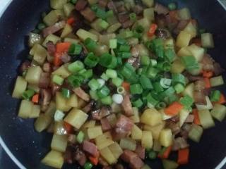 腊肉土豆焖饭,翻炒均匀后倒入葱花翻炒均匀关火。食材不用炒熟，因为还要放入锅中焖的。
