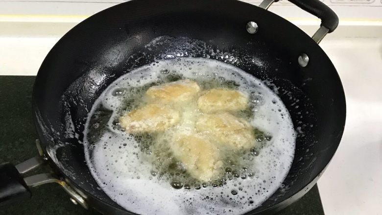 韩式吮指炸鸡翅,食用油加至7～8分热时，把鸡翅放入锅中转中火炸制，鸡翅放入锅时不要急于翻动，大约1～2分钟后再去翻动。