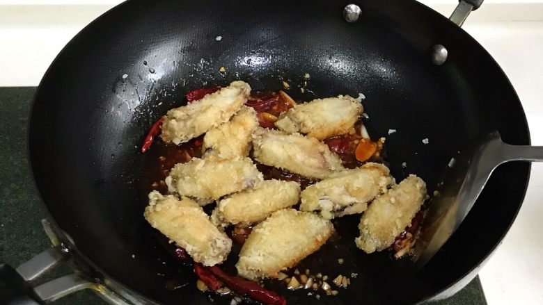 韩式吮指炸鸡翅,加入炸好的鸡翅，翻炒几下。