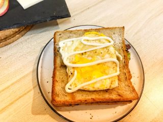 巨无霸早餐三明治😋,盖上一层面包片，放上糖心蛋，挤上沙拉酱。