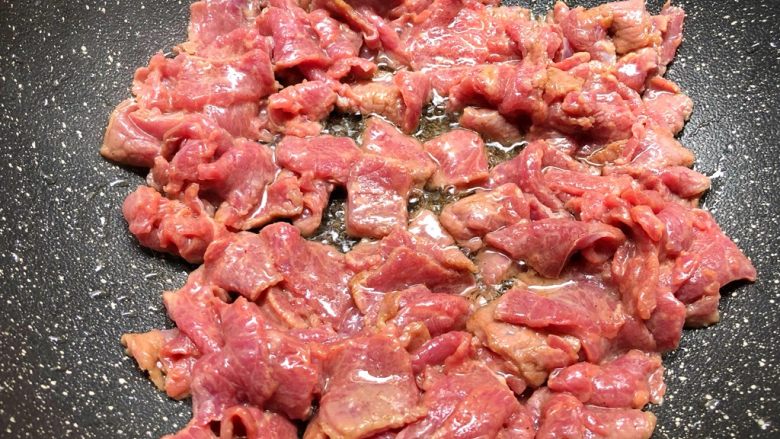 铁板牛肉,热锅放入适量油，放入腌制好的牛肉翻炒