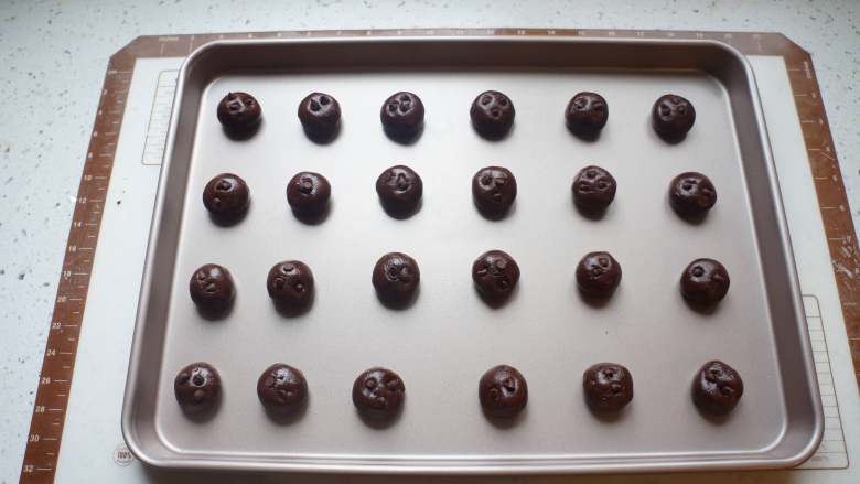 巧克力豆软曲奇,面团分成18克一个的剂子揉圆，均匀放在烤盘上，上面点缀几个巧克力豆