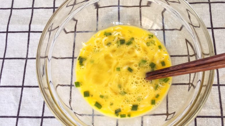 宝宝辅食12M➕：银鱼炒鸡蛋,洗净的银鱼放入鸡蛋碗里，加入葱花，搅拌均匀