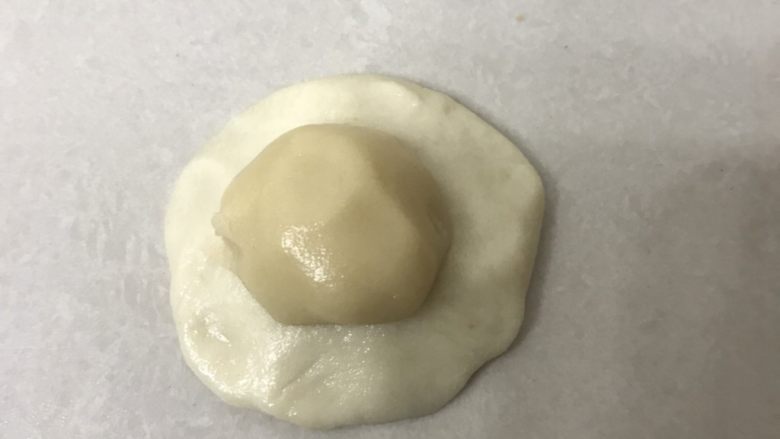芝麻小脆饼,取一油皮面团用手掌按扁放上油酥面团。