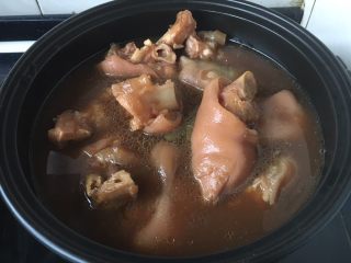 黑豆黄豆猪手煲,将适量的煮过的猪手和汤倒入砂锅里。