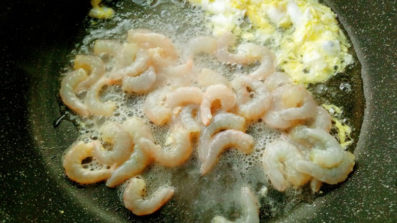 虾仁炒饭,鸡蛋炒七分熟，划到锅的一边，放入腌好的虾仁翻炒。