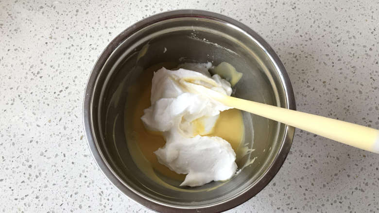 原味8寸戚风蛋糕,刚才准备好的蛋黄糊再搅拌几下，经过刚刚打蛋白的时间，蛋黄糊通过静置后会变得更加细腻柔软。放入1/3蛋白。