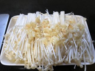 金针菇炖豆腐,将炒好的蒜末连油一起平铺在金针菇表面。