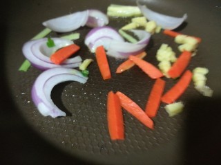 快手菜，五彩杂蔬肉丝爆虾,另起一锅，热油至七成，加入姜蒜、洋葱、胡萝卜快速翻炒，至洋葱变透明。
