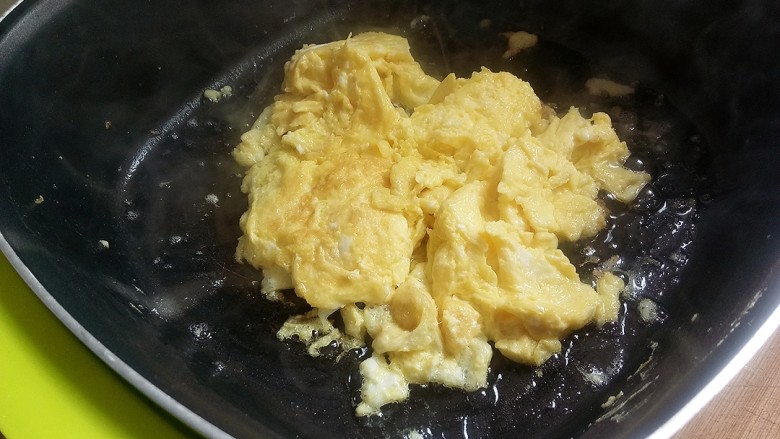 蒜薹炒鸡蛋,倒入有油的锅中炒至成型，盛出备用