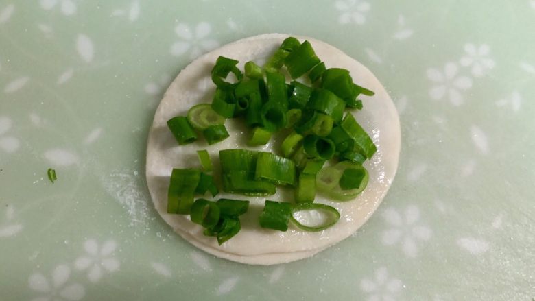 饺子皮葱油饼,撒上一些盐，铺上一层葱花。