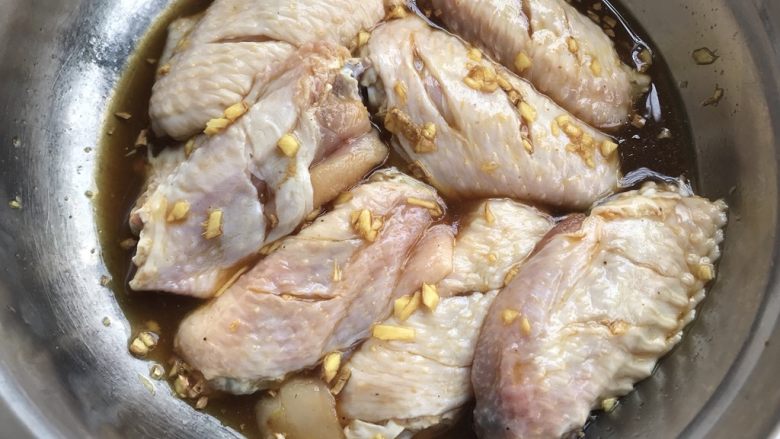 柠檬姜蓉蜂蜜烤鸡翅,把酱汁淋入鸡翅中，并且按摩一下，盖上保鲜膜，冷藏4小时以上，中途翻面腌。