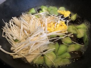 低脂晚餐之农家丝瓜煲,开盖加入鸭蛋和金针菇，翻炒均匀。加盖再次煮开。