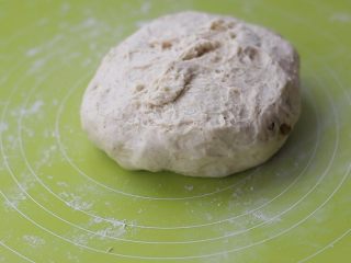 无油无糖葡萄干欧包,将发酵好的面团倒扣在揉面垫上