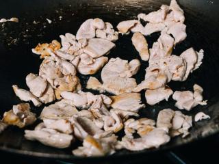 泰国辣酱炒鸡肉,热锅加油加鸡肉。将鸡肉翻炒1-2分钟，直至微微有点烤焦。