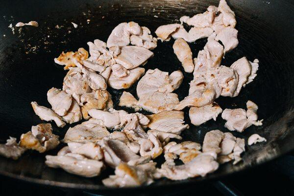 泰国辣酱炒鸡肉,热锅加油加鸡肉。将鸡肉翻炒1-2分钟，直至微微有点烤焦。