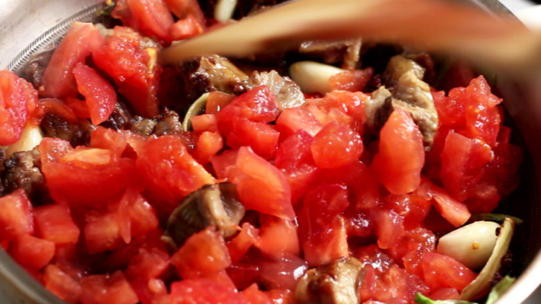 西红柿炖牛腩,锅中加入一半量的西红柿块，翻炒至西红柿变软出水。