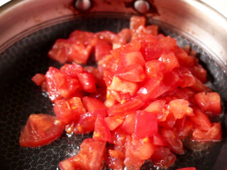 西红柿炖牛腩,锅中再次加油，将剩下一半的西红柿块炒软出沙，将炖好的牛腩连同汤汁一起倒入锅中。