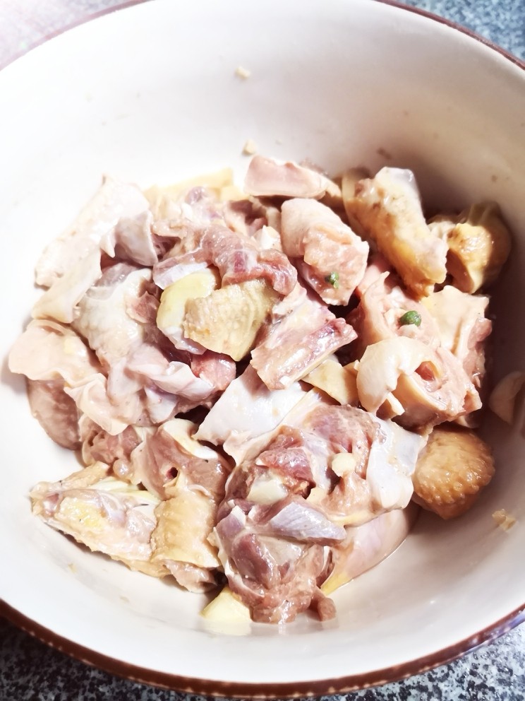 芋儿鸡,腌制半小时后，摘出青花椒叶。加入淀粉搅拌，让鸡块裹上一层薄粉