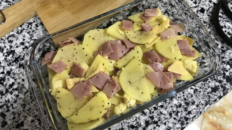 芝士培根焗土豆,搅拌一下，放进烤盘里