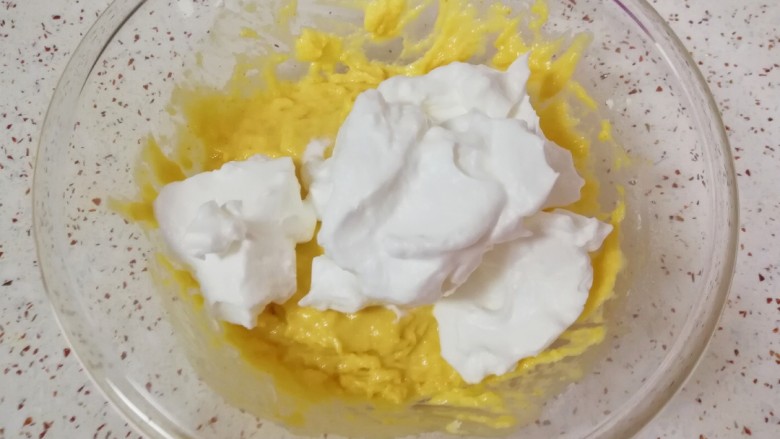 南瓜米糊华夫饼,打发好的蛋白分成两份，取二分之一加入到米糊蛋黄糊里面翻拌均匀。