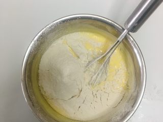 轻芝士蛋糕,这个时候取出隔水加热的芝士糊，把玉米淀粉和低筋面粉过筛加入芝士糊里，搅拌均匀至顺滑无颗粒。