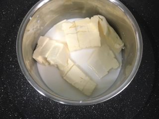 轻芝士蛋糕,牛奶倒入碗中，把切成小块的奶油芝士也倒入碗内，隔水加热糊化。