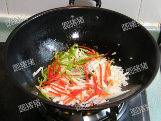 酸笋炒肉,将青红椒丝，酸笋丝炒入炒至断生。