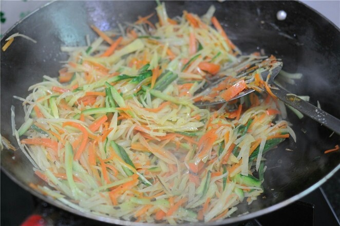 蒸饼卷菜,加入胡萝卜丝和黄瓜丝一起炒熟，加入盐调味即可出锅备用