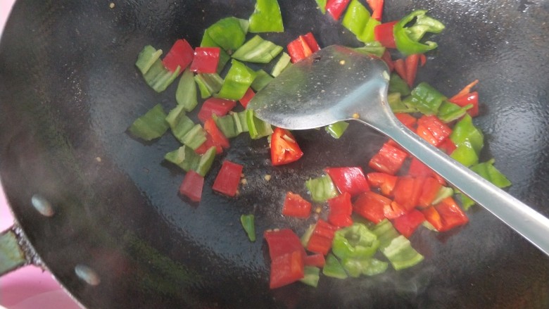 辣炒鸡胗,锅内的底油，放入青椒，红椒，翻炒。