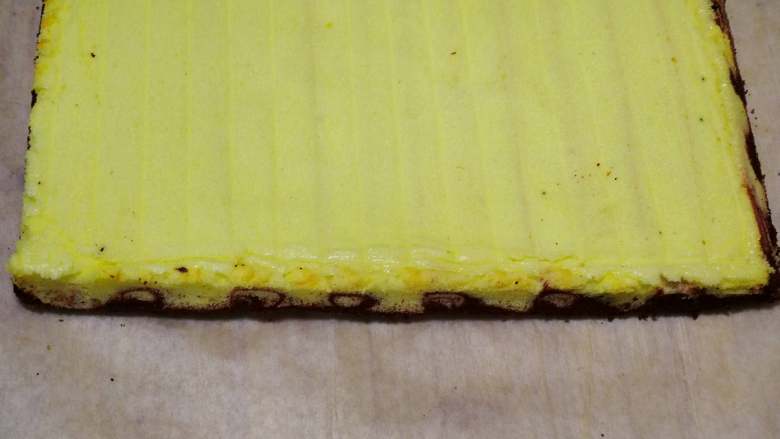 旋风蛋糕卷[红丝绒],要平行于最后一次花纹卷，不然会没有花纹。如果分辨不清了也没关系，用锯刀切掉四周边角，这种有花纹的侧边卷的时候在左右两侧就对了。