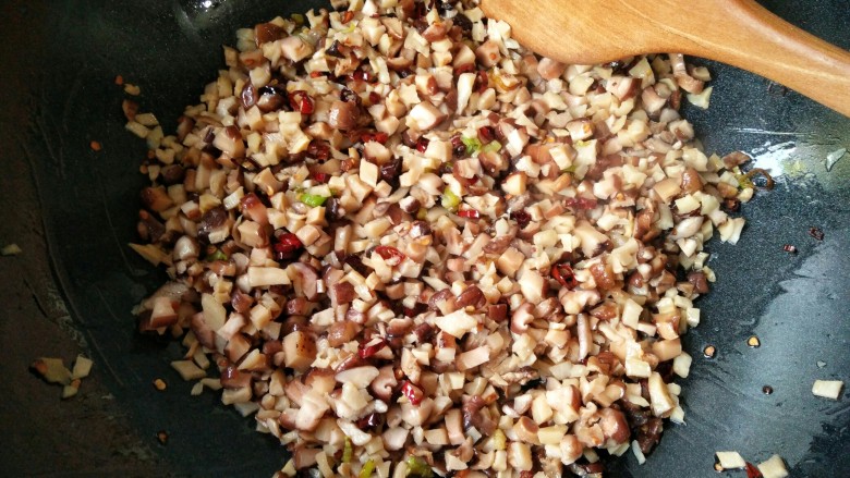 香辣笋丁菌菇酱――下饭必备,倒入切好的笋丁和菌菇丁，翻炒均匀。