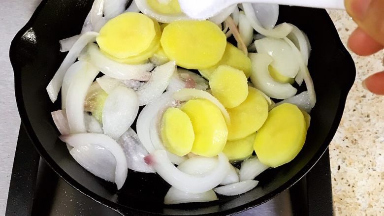 干酪片北非蛋,将土豆片倒入锅中，加入适量的盐翻炒均匀