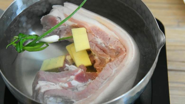 粉蒸肉—软软糯糯，肥而不腻入口即化,五花肉冷水下锅，放入葱结、姜片，淋入1勺料酒。